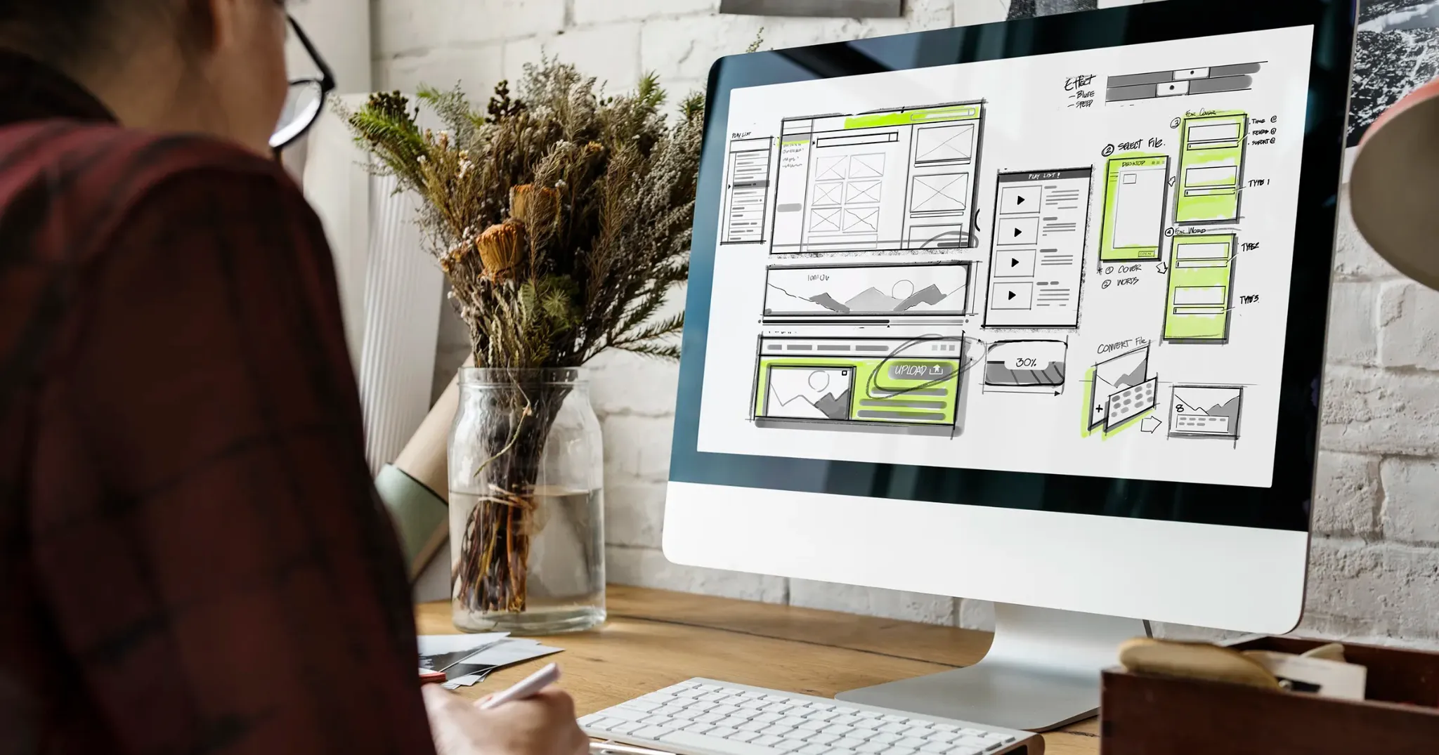 Designer reviewing a homepage wireframe and content layout on a desktop screen